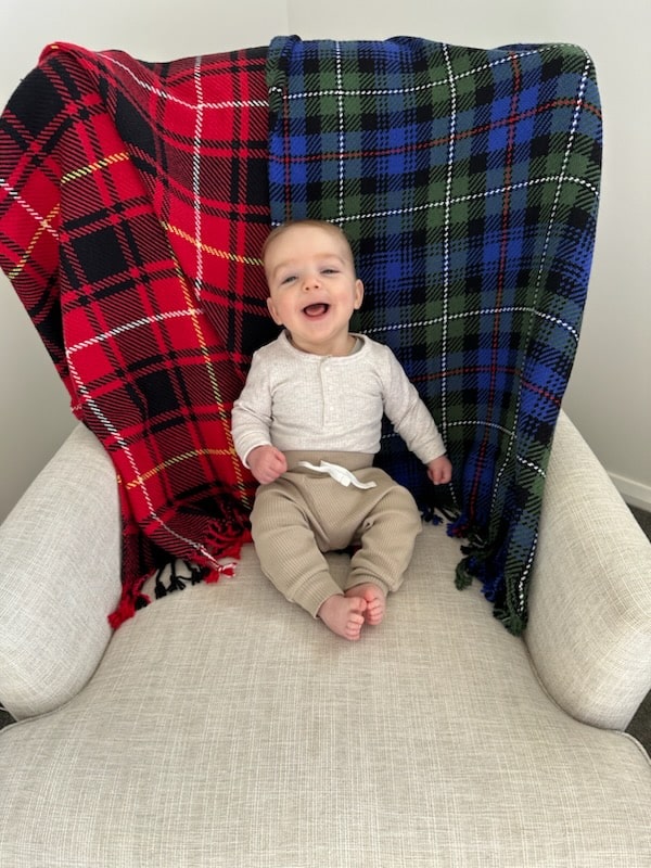 Baby sitting in chair with baby blankets